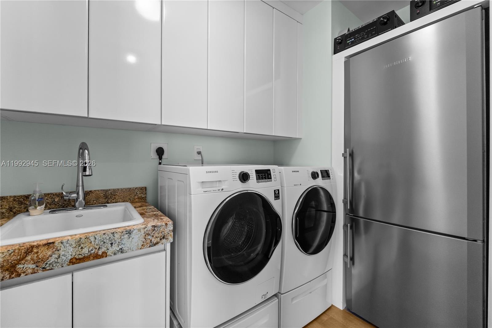 Laundry room with a sink and an extra refrigerator!