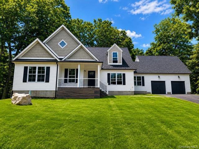 Stunning front exterior showcasing timeless architectural details, covered front porch, oversized two-car garage, mature trees, and expansive lawn.
