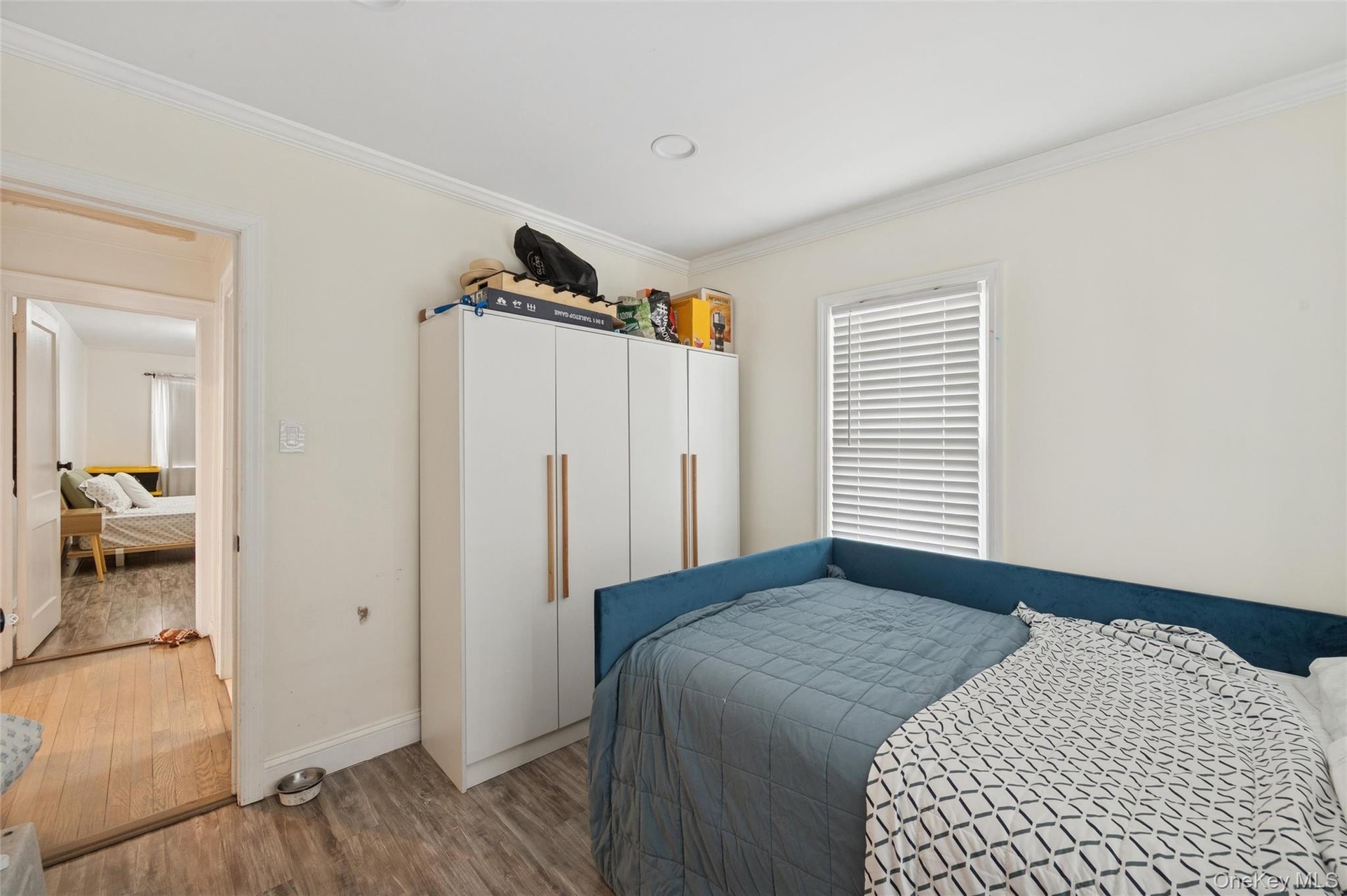 Bedroom featuring wood finished floors and ornamental molding