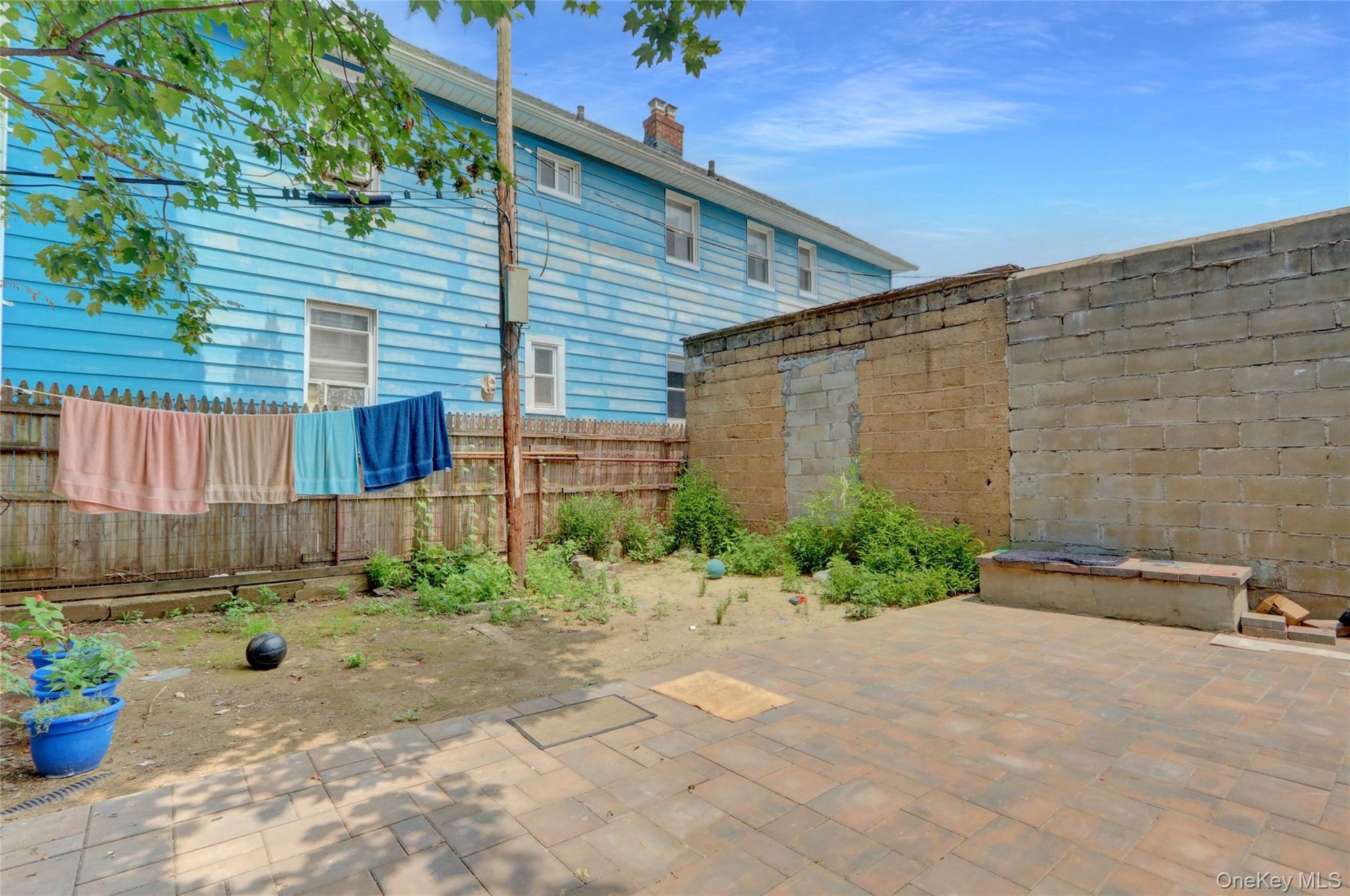 Outdoor patio area with paver flooring, a perimeter block wall, and an integrated block bench
