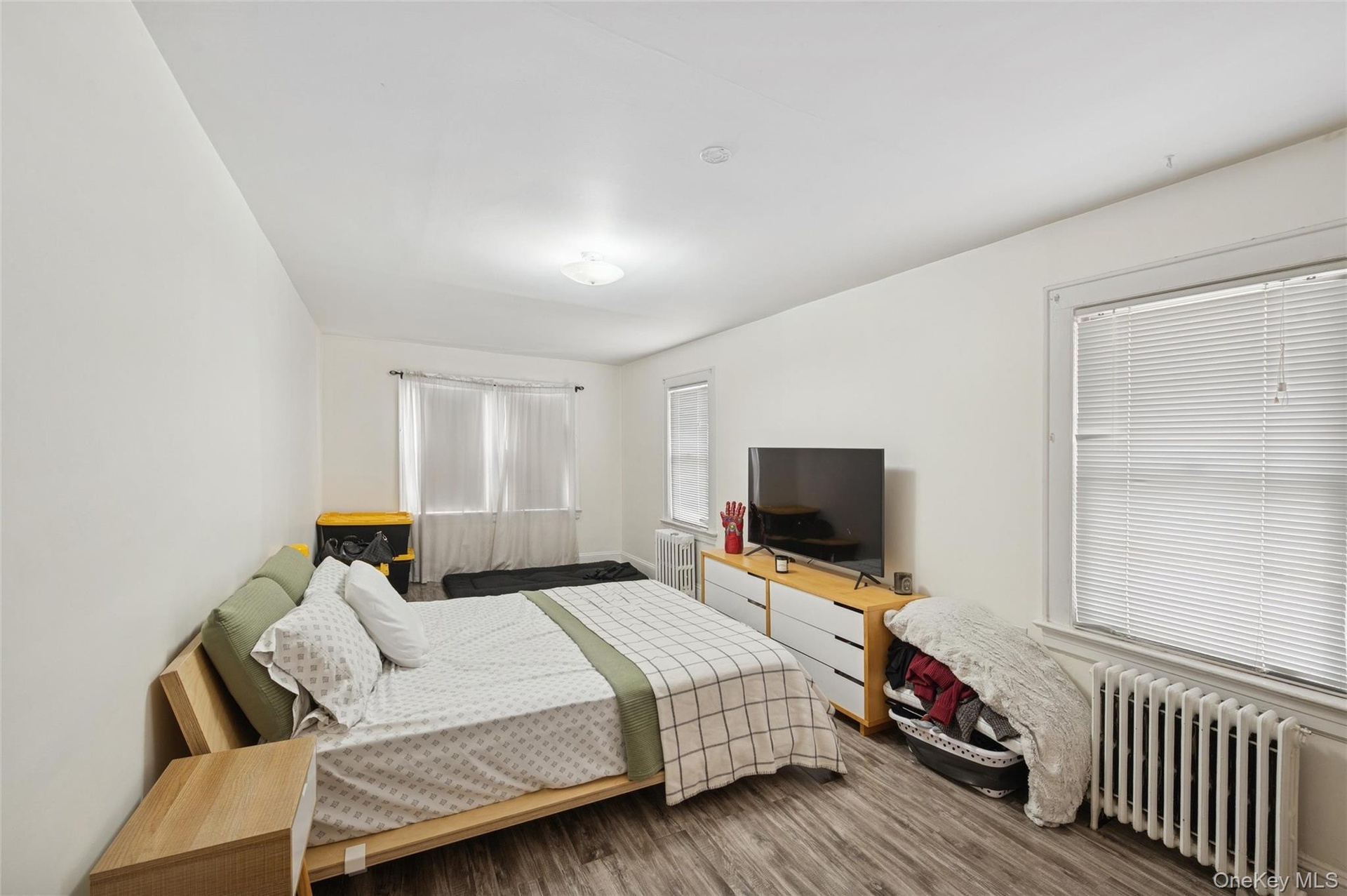 Bedroom featuring radiator heating unit and wood finished floors