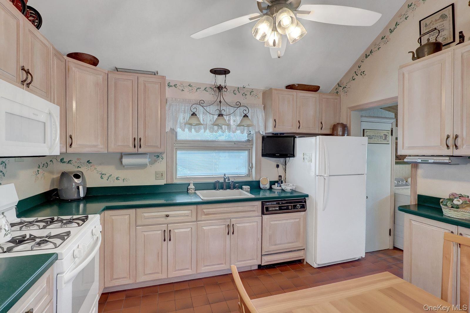 Eat-in kitchen with wood cabinets, Corian countertops, and Cath Ceiling