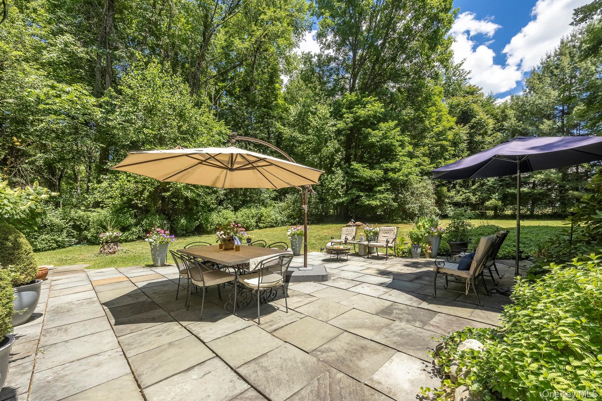 Sit on the beautiful patio and enjoy the view of the spacious backyard