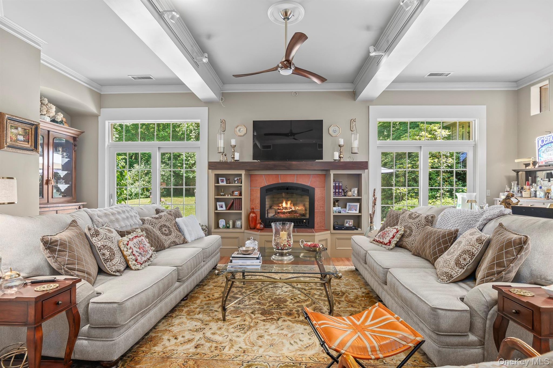 The great room/family room has a fireplace, high ceilings & two sets of French doors out to the stone patio & back yard