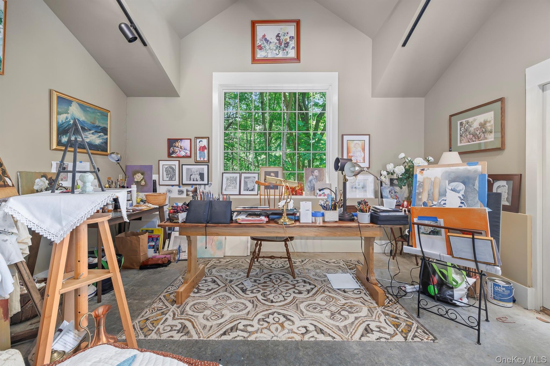 A wonderful art studio with very high ceiling has a private patio and glass sliding doors, offering great light