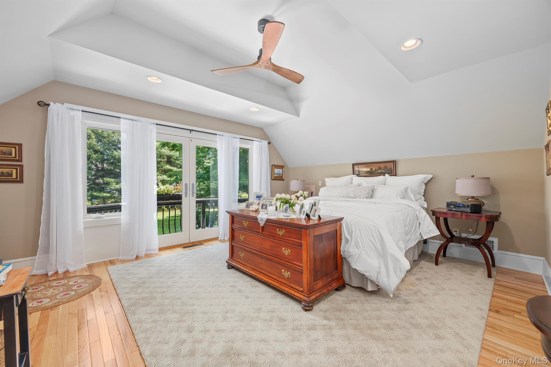 A very large, fabulous light-filled primary bedroom with a juliet balcony overlooks the back yard