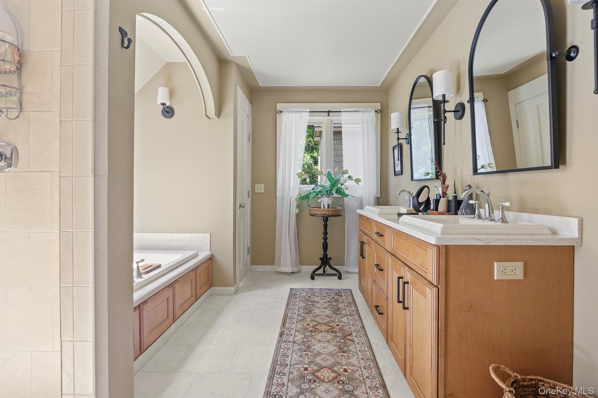 Spacious primary bath with shower and soaking tub is one of 3.5 bathrooms