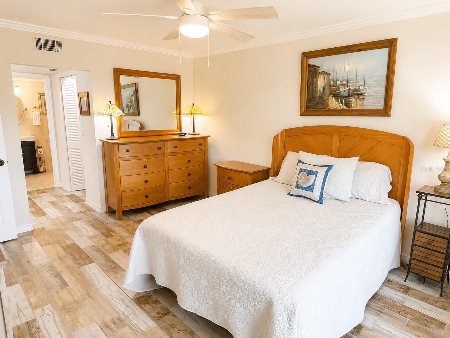 Primary bedroom with tile flooring, ceiling fan.