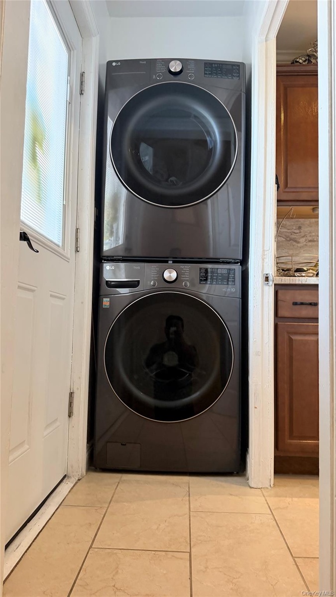 Stackable laundry appliances with front-loading design, set within a dedicated alcove