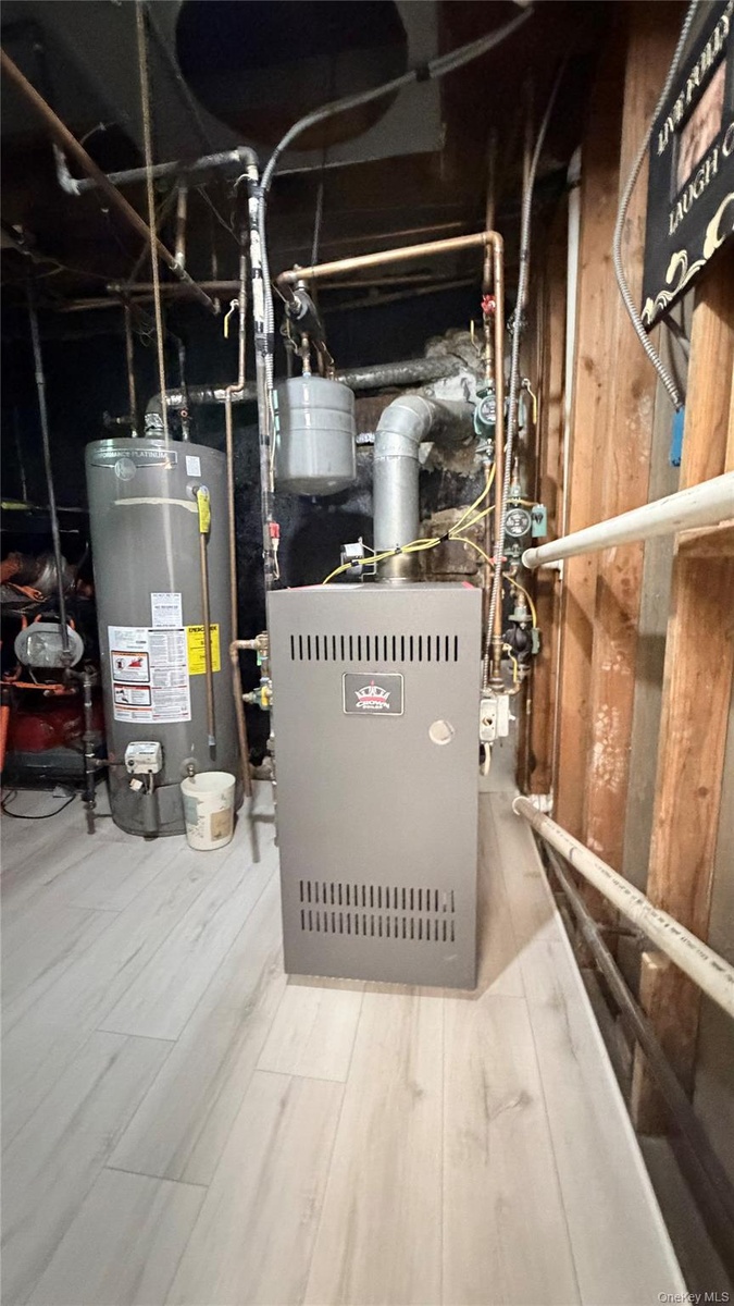 Mechanical room featuring a new gas furnace unit, hot water heater,