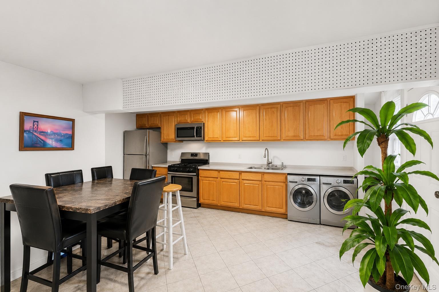 Kitchen area featuring wood cabinetry, stainless steel appliances, and a double basin sink