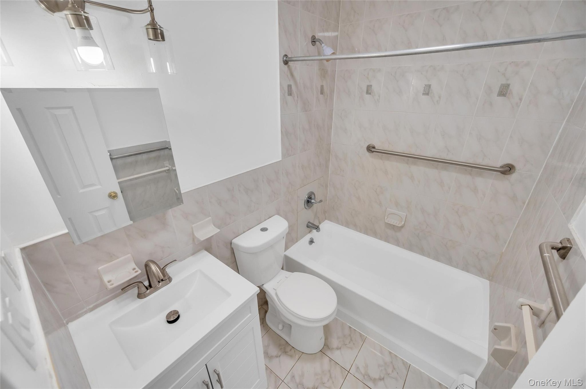 Bathroom featuring a white vanity with a basin sink, brushed nickel faucet, and a wall-mounted mirror