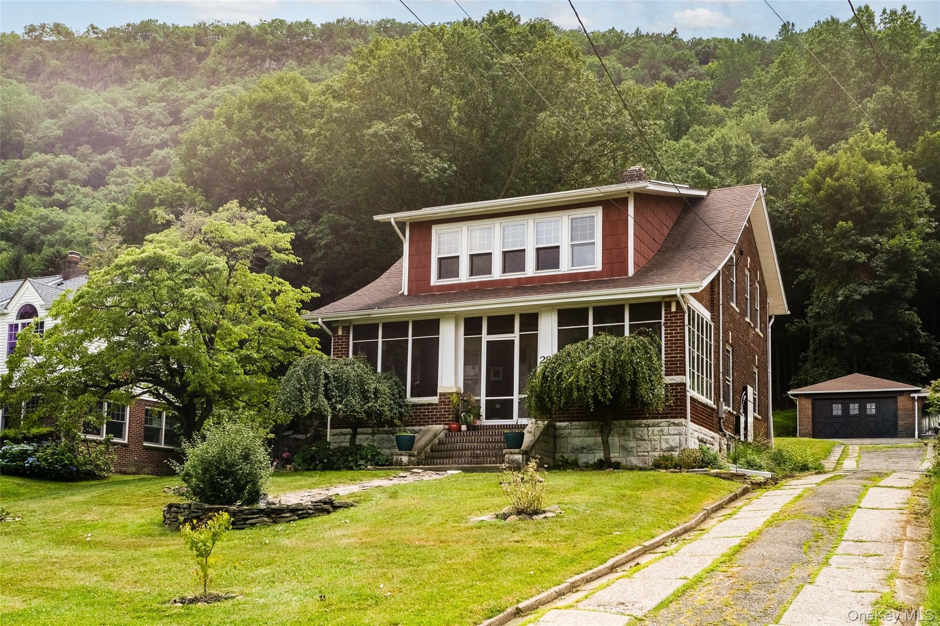 Driveway view and 2-car garage. Total parking for 7 cars on property.