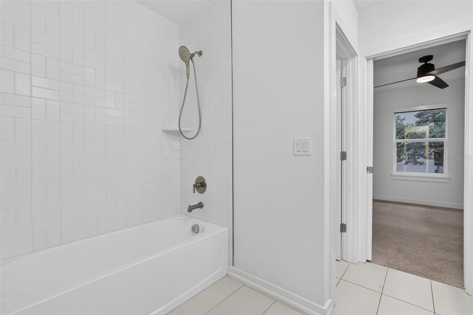 Guest Bathroom Shower tub combination water closet seperate with door and access to one of the bedrooms
