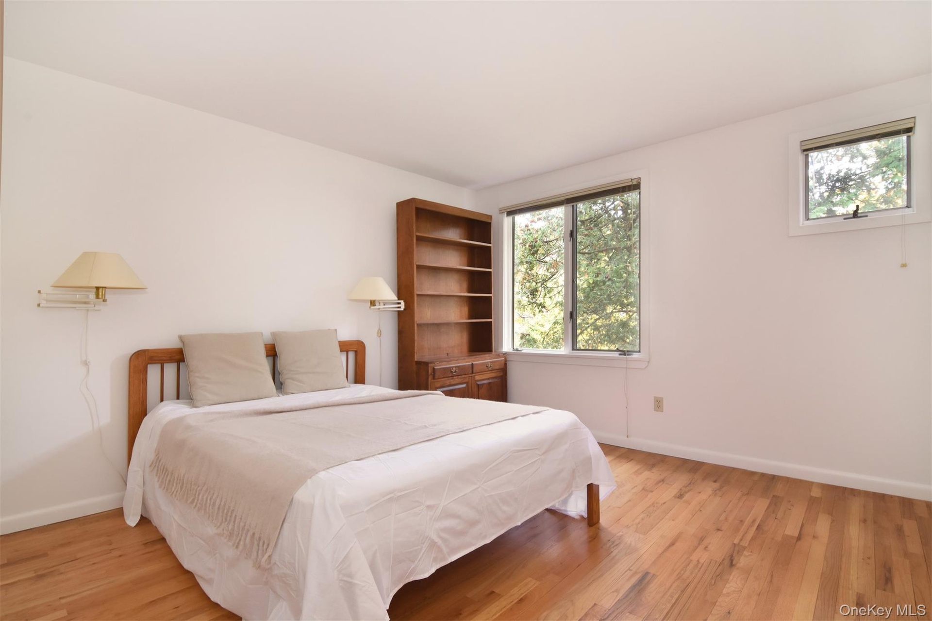 Large second Bedroom with light wood finished floors and 2 closets