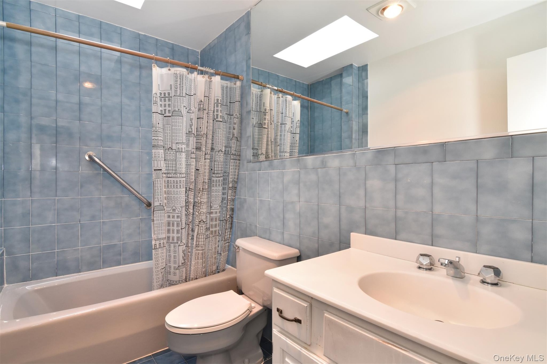 Skylit hall bathroom with vanity, shower and bathtub on second floor