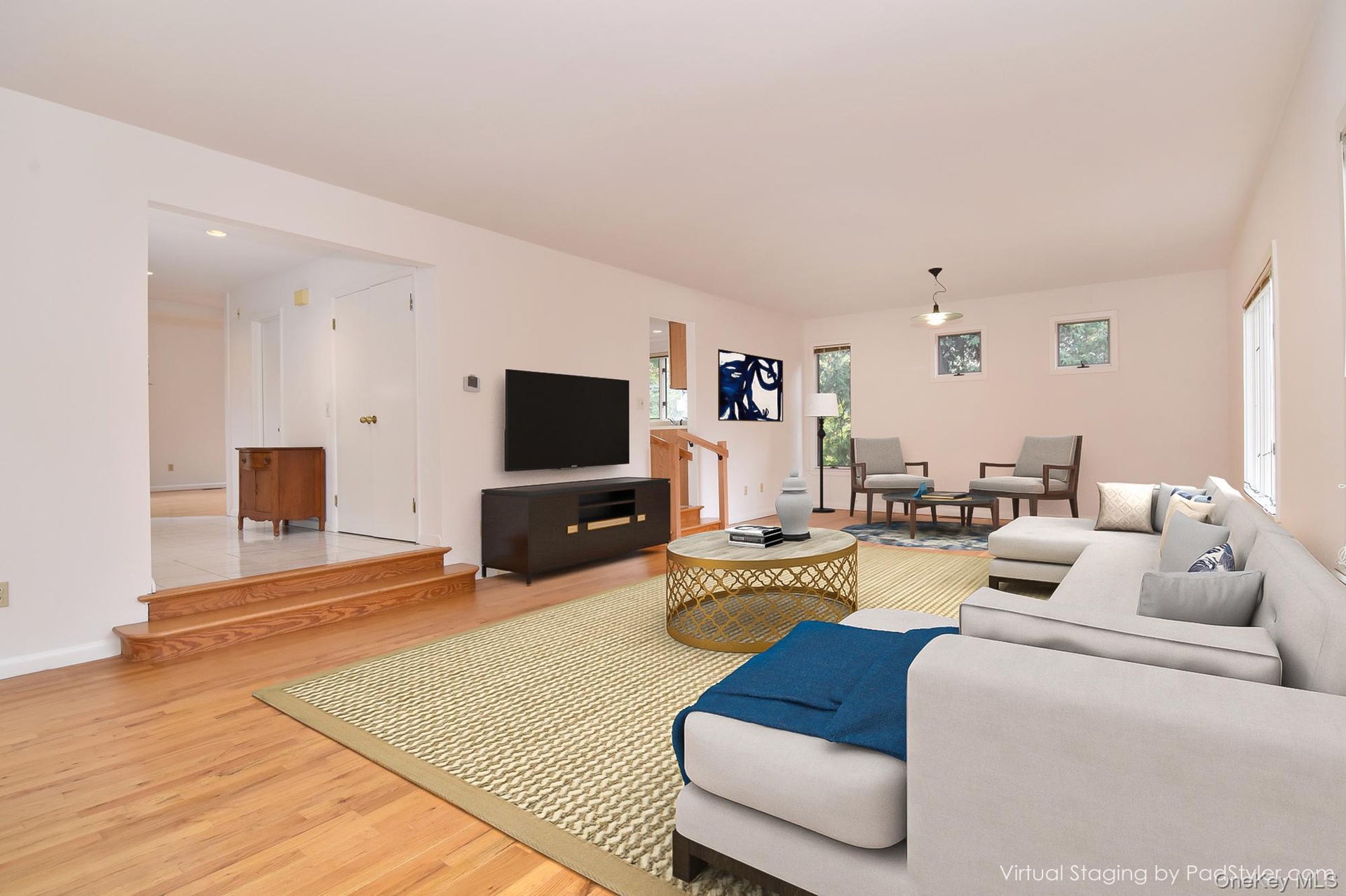 Virtually staged 30' Great Room with wall space for large TV and light wood finished floors