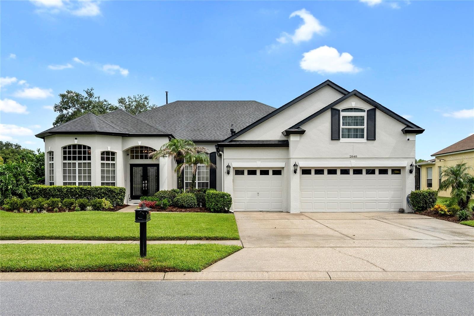 front with mature landscape and 3 car garage