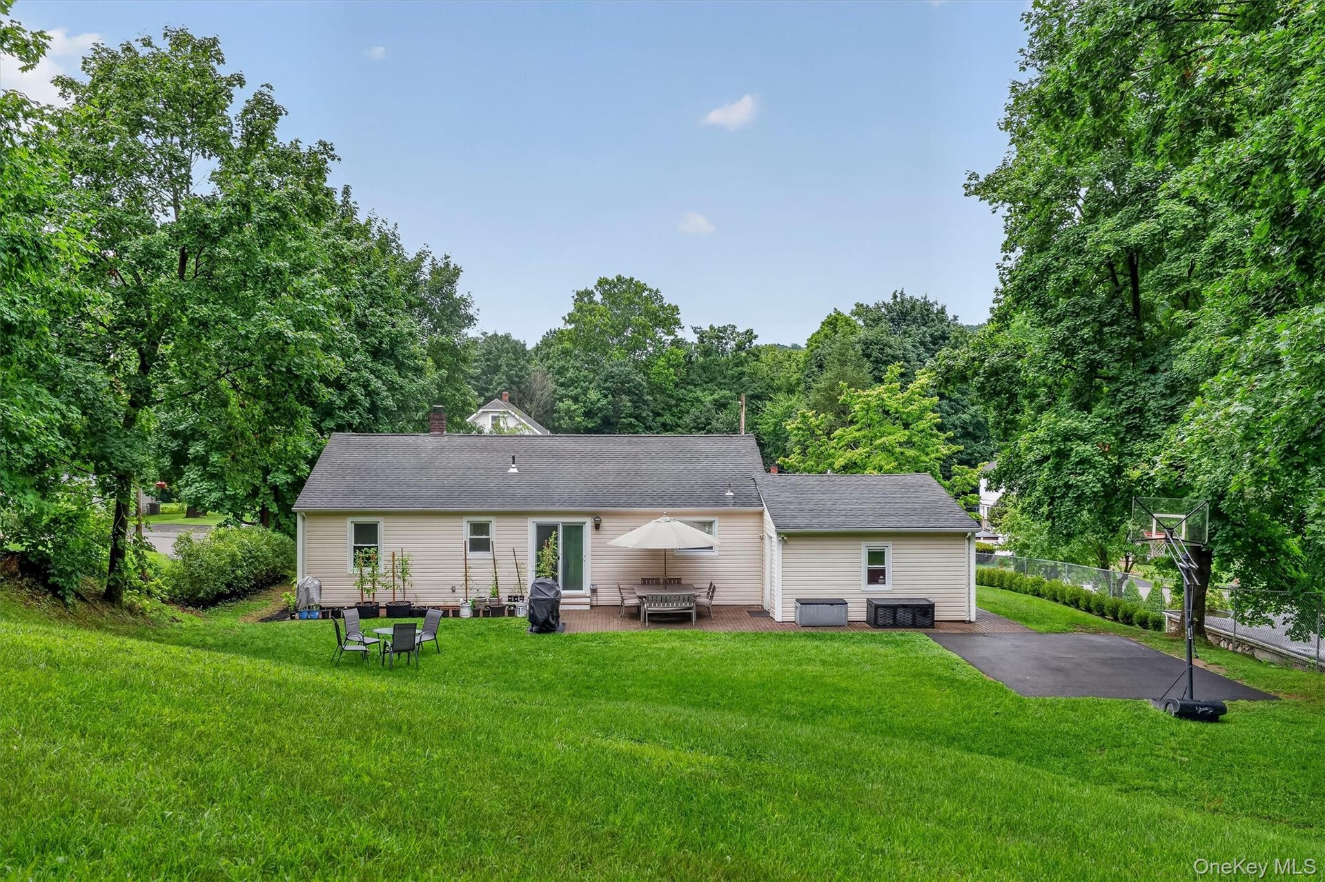 Private backyard features a spacious paved area offering plenty of flexibility for a basketball court, recreation area, or other outdoor activities.