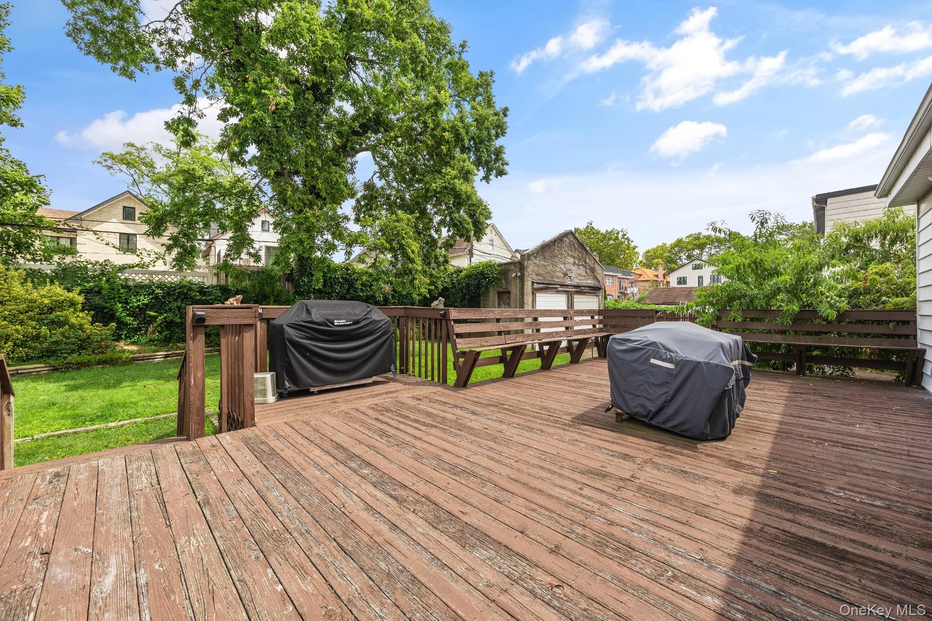 Expansive rear wood deck offering generous space for outdoor dining, grilling, and entertaining while overlooking the spacious backyard. Thoughtfully 