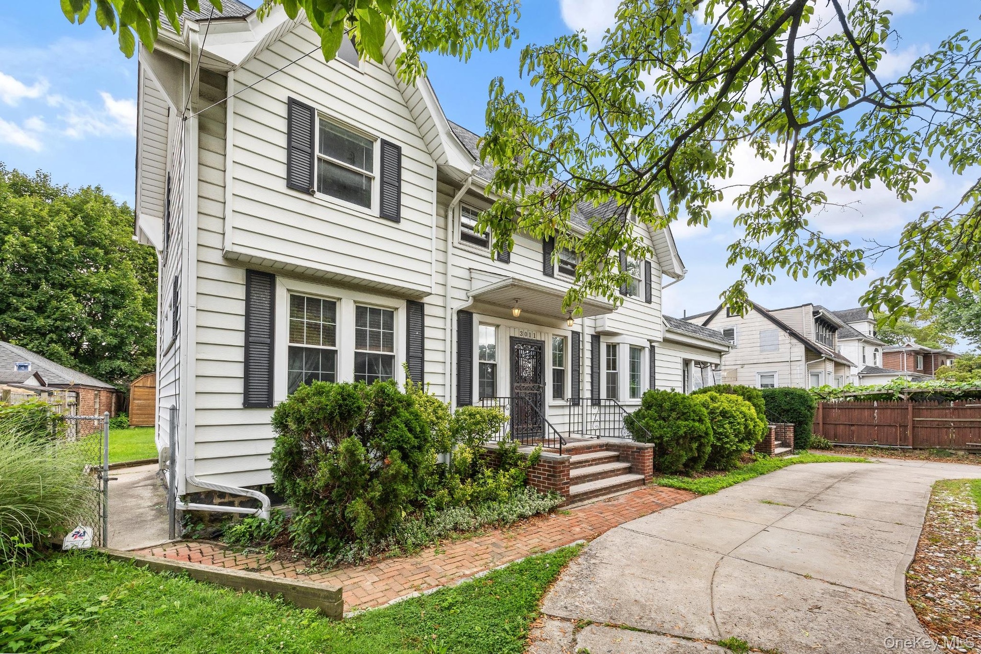 Front of Structure – Elegant front exterior showcasing timeless architectural design, steep gabled rooflines, mature landscaping, and a welcoming cove