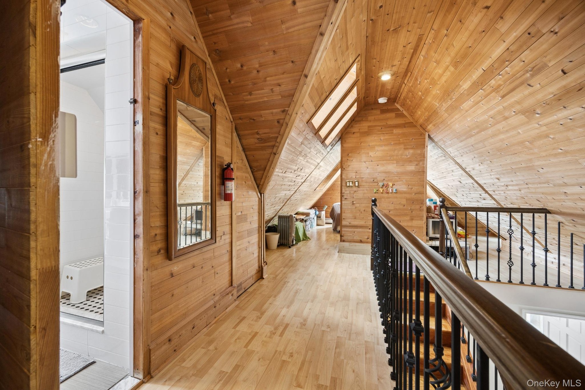 Finished Attic / Loft- Beautifully finished attic featuring warm wood-paneled walls and vaulted ceilings, skylights, and an open loft-style layout. Th