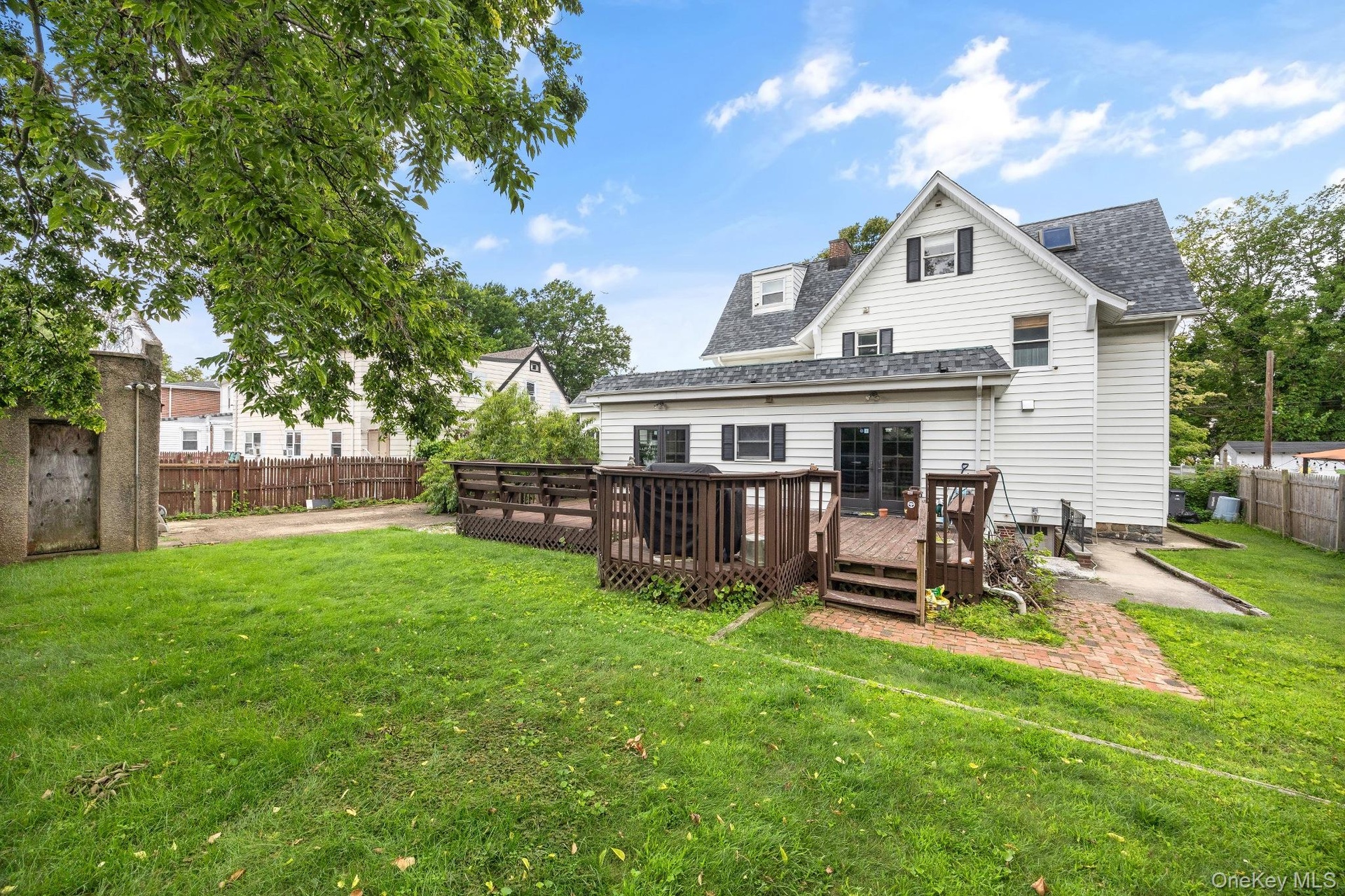 Backyard – Spacious backyard featuring a large wood deck, expansive lawn, and mature trees that provide a welcoming outdoor setting. Offering plenty o