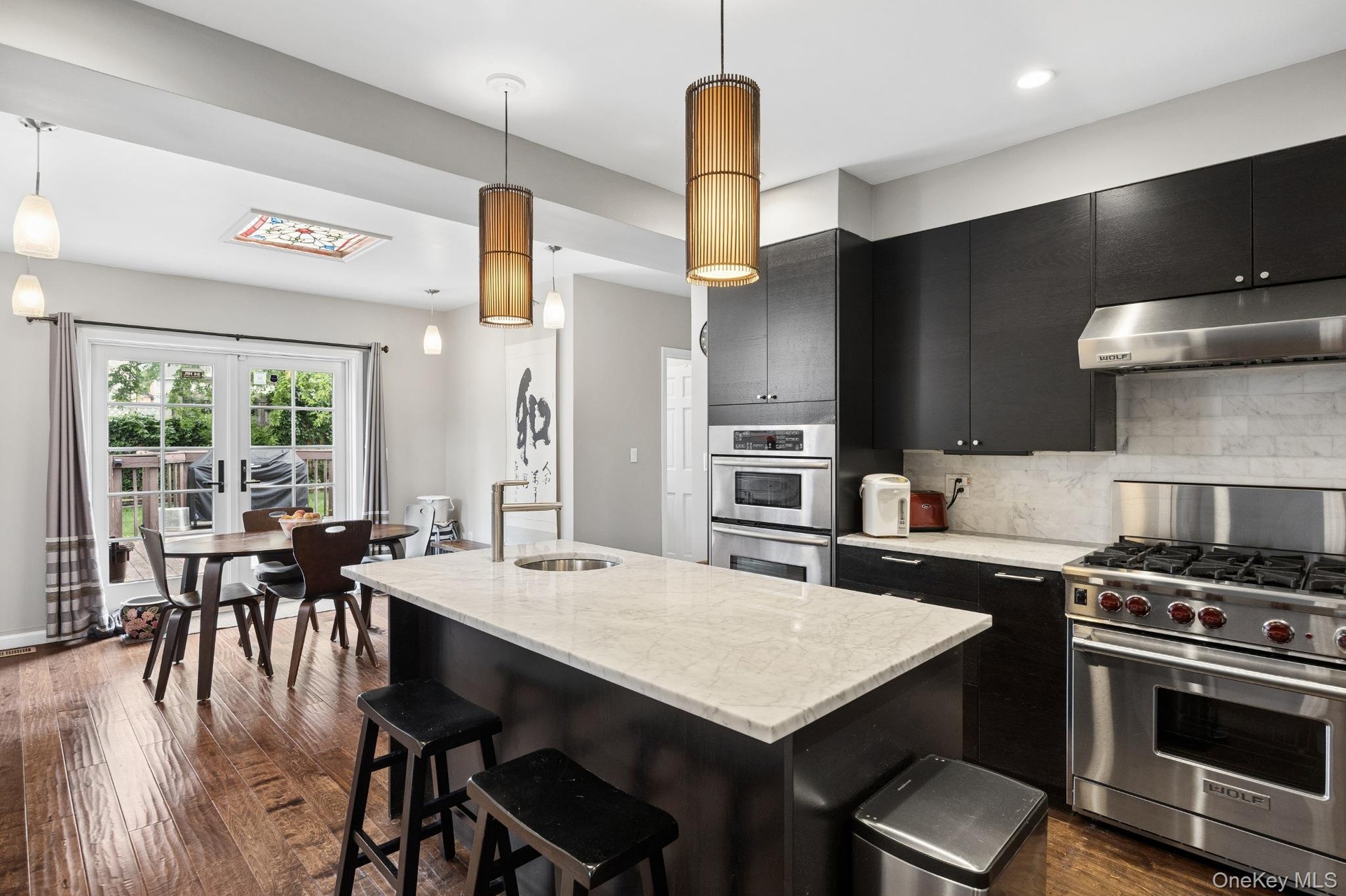 Stunning gourmet kitchen featuring custom cabinetry, quartz countertops, a large center island with seating, and premium stainless steel appliances, i