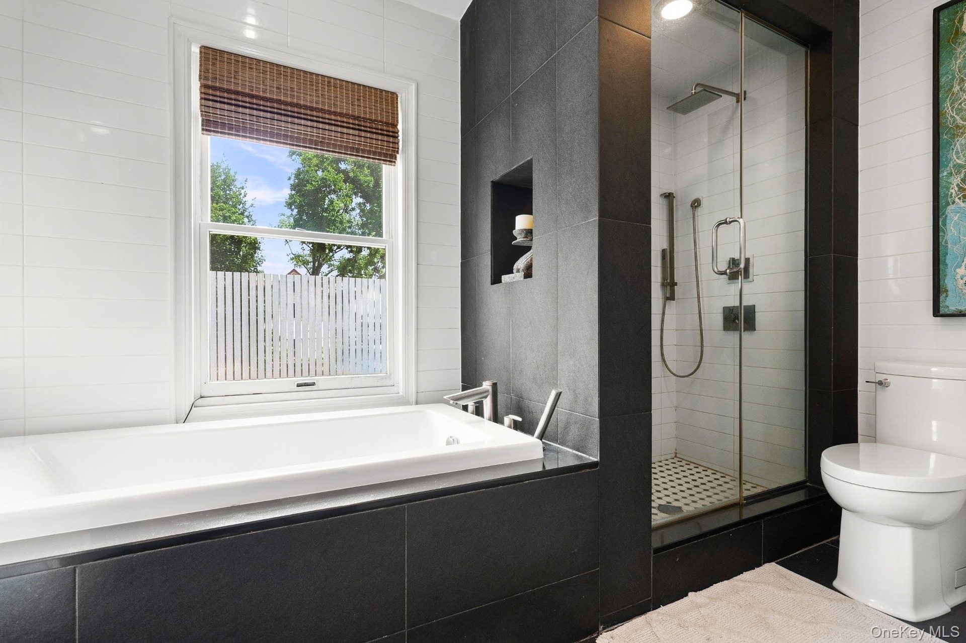 Primary Bathroom – Luxurious primary bathroom featuring a deep soaking tub, spacious glass-enclosed walk-in shower, contemporary tile finishes, and a 