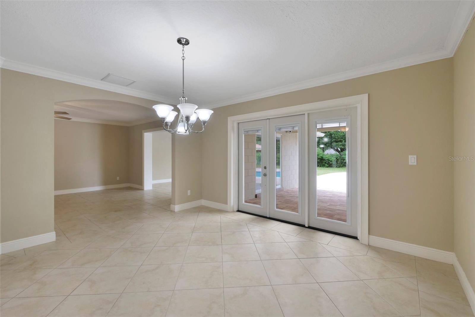 GRACEFUL ARCHED OPENINGS lead to the formal Dining Room, where French doors invite you outside to your PRIVATE BACKYARD RETREAT.