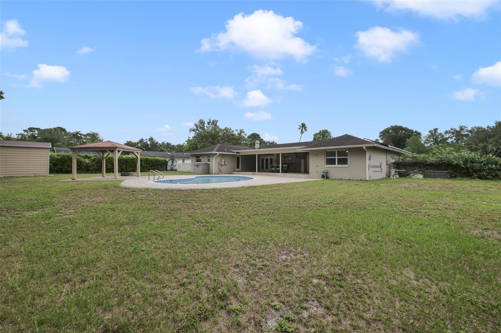The EXPANSIVE BACKYARD offers endless possibilities with a charming gazebo, a cozy fire pit for evening gatherings, and a storage shed for added conve