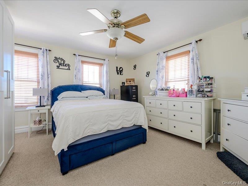 Master Bedroom featuring light-colored wall paint, two windows with wood blinds and curtain rods, and a ceiling fan with light fixture