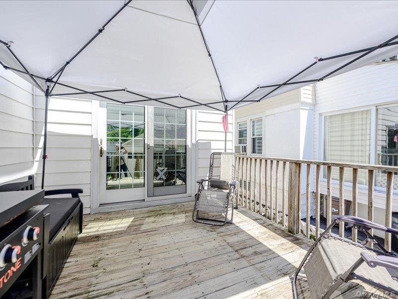Expansive wooden deck with a white tent