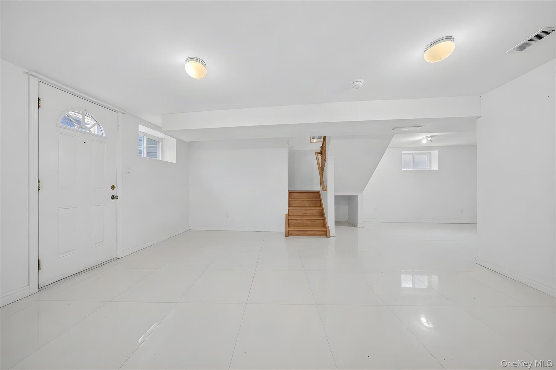 Spacious finished basement featuring polished concrete flooring, recessed ceiling lighting, and multiple egress windows
