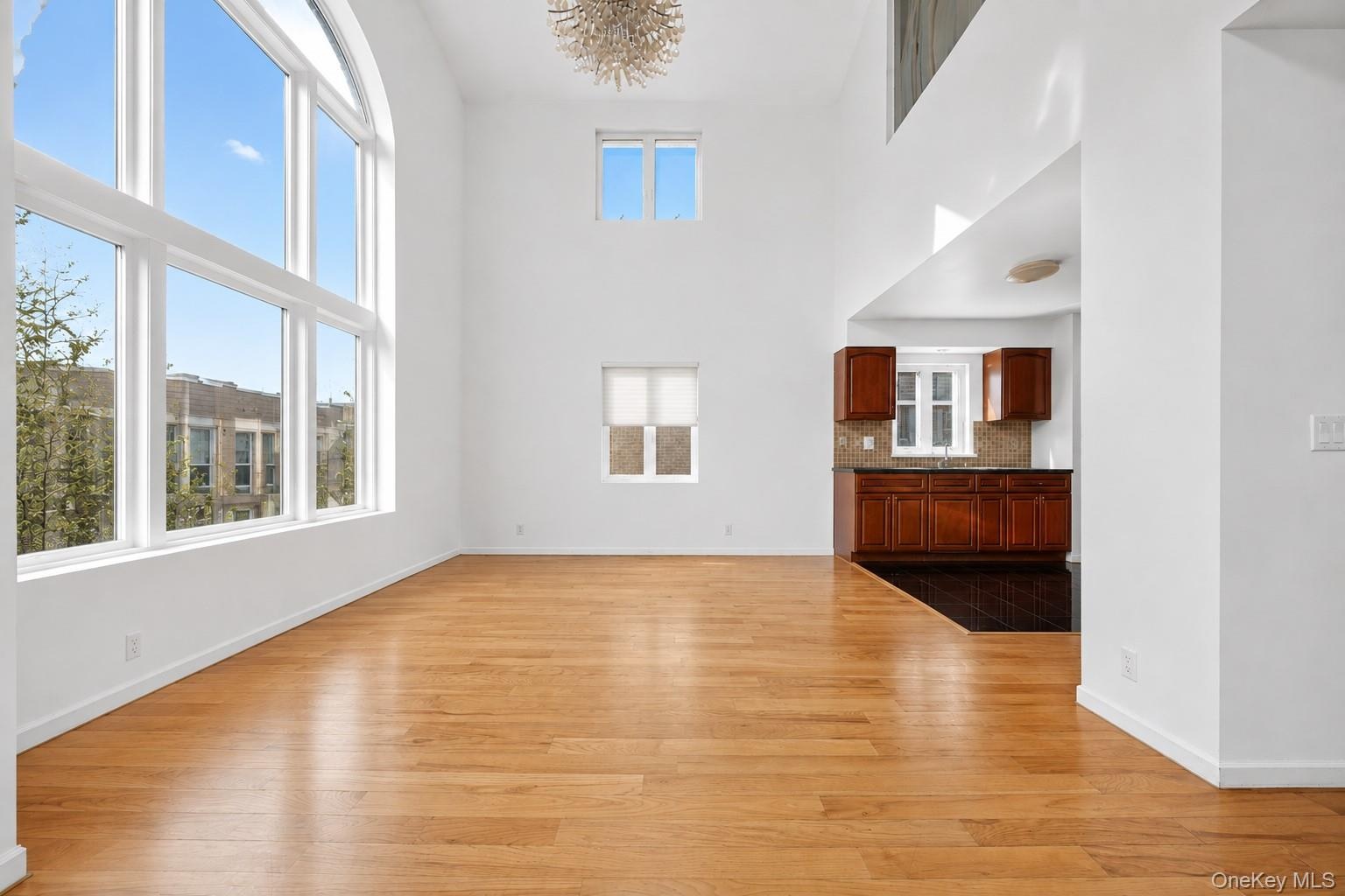 Expansive living area with soaring ceilings and light wood-finish flooring