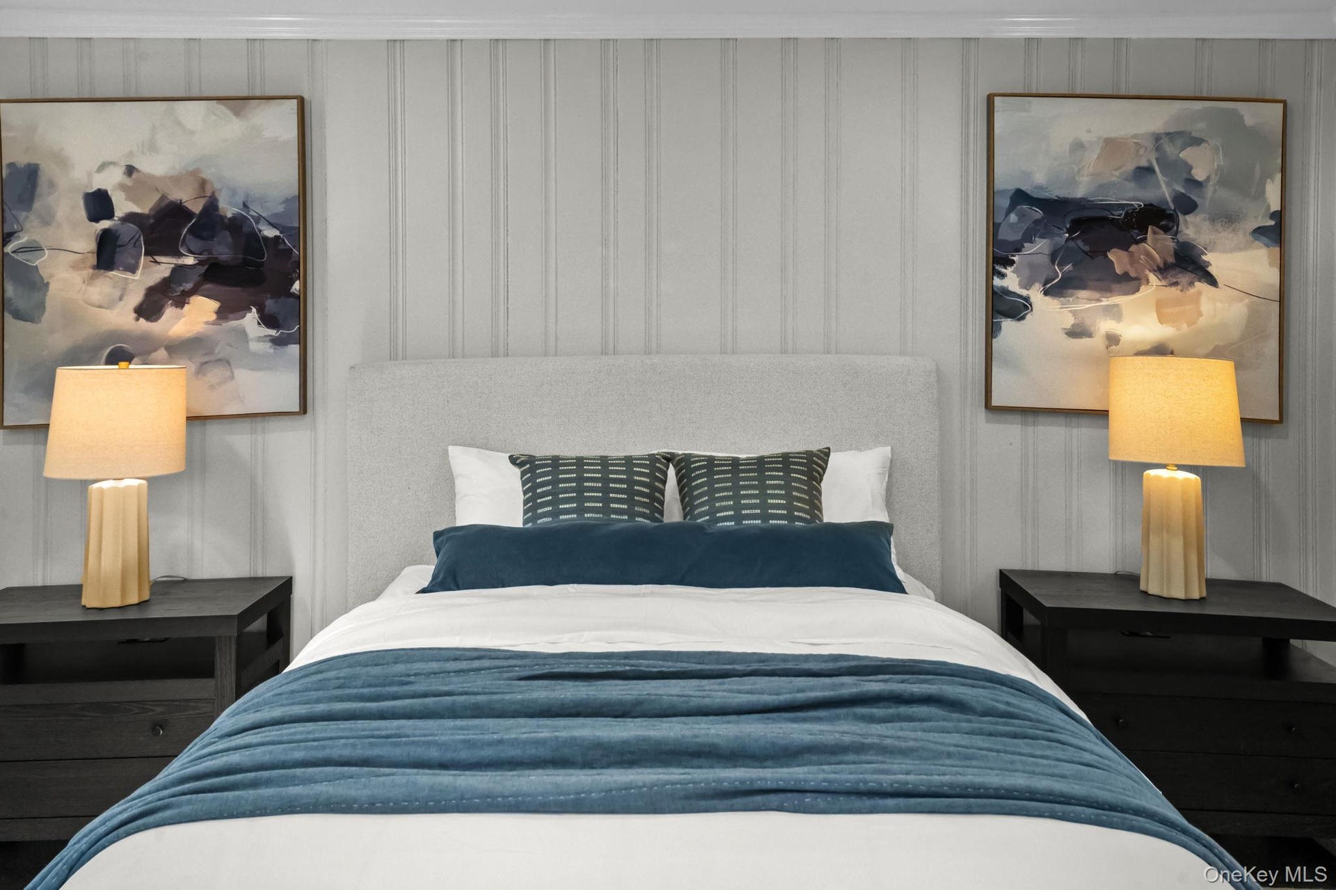 Custom wall paneling and updated lighting elevate the style and warmth of this beautifully finished bedroom.
