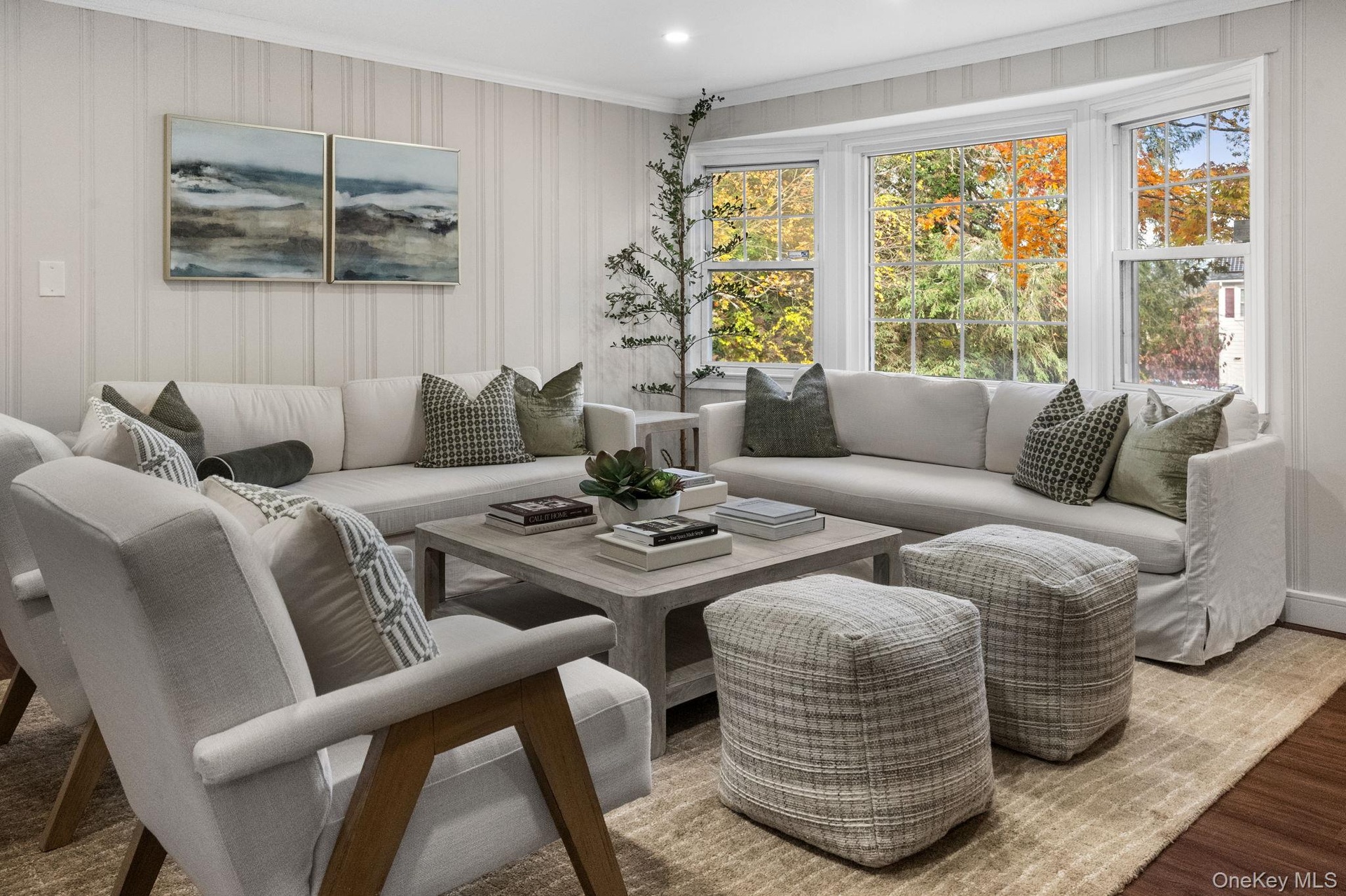 Bright and comfortable living room showcasing timeless updates and a peaceful view of the tree-lined property.