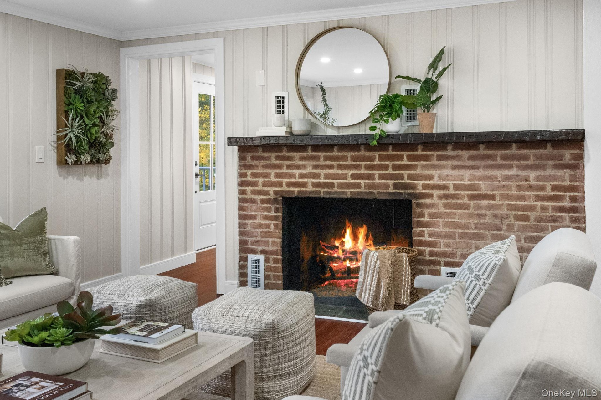 A classic brick hearth adds warmth and timeless character to this newly renovated gathering space.