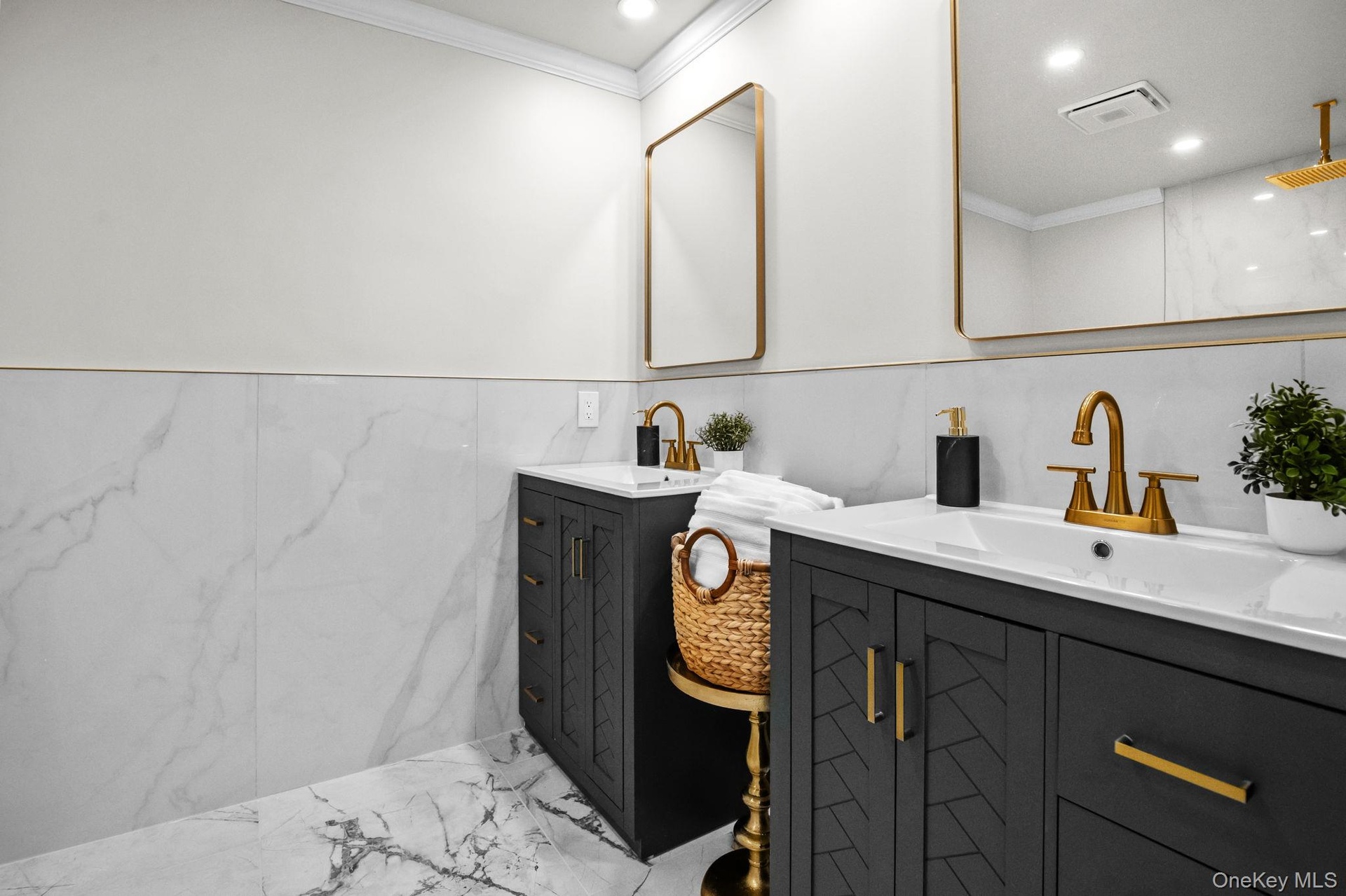 Dual vanities with quartz counters, gold fixtures, and modern mirrors create a sleek and luxurious setting.