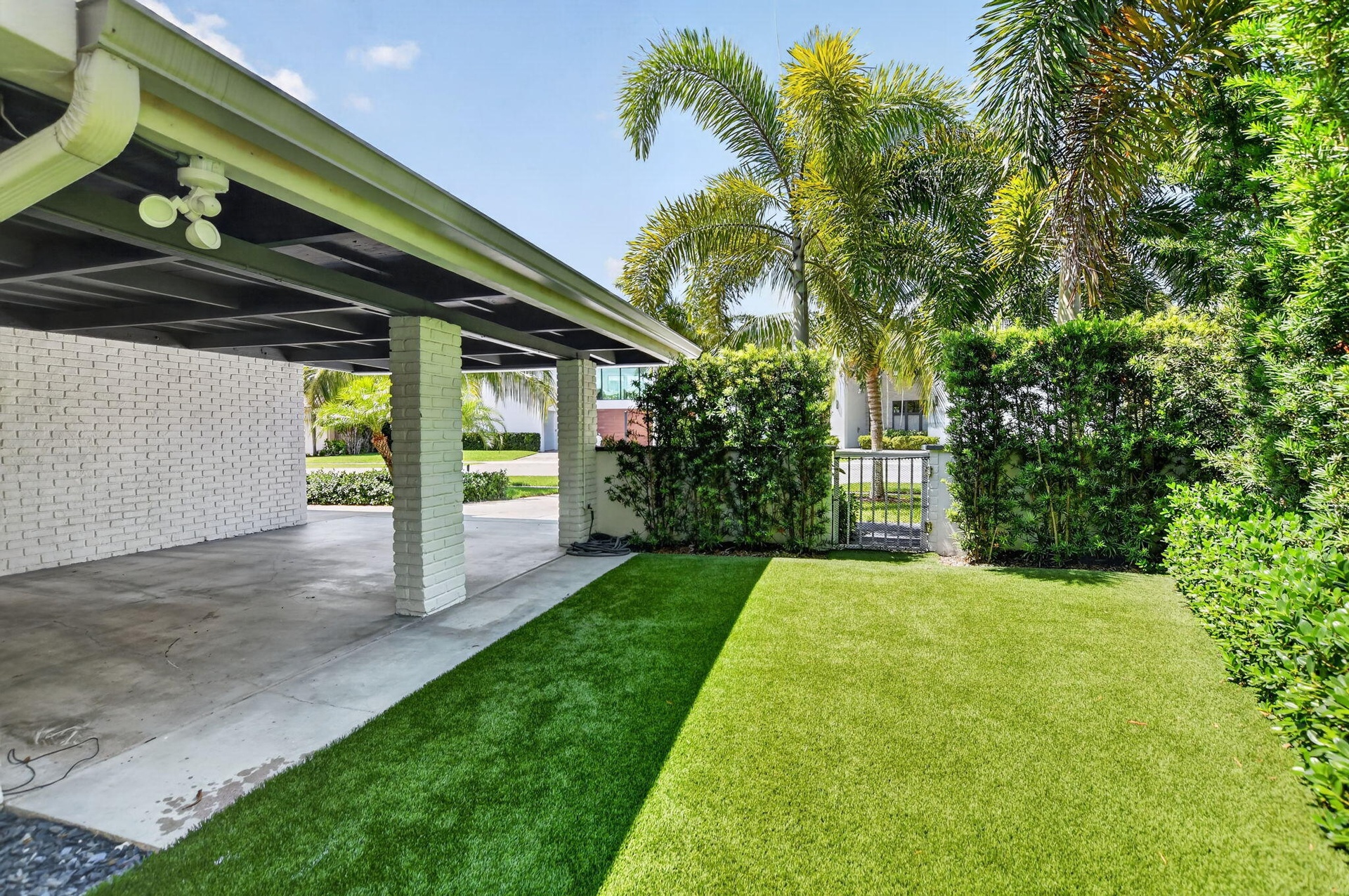This is the West side elevation of the Carport, the yard is partially fenced in . The side and rear yards have recently installed artificial turf, no 