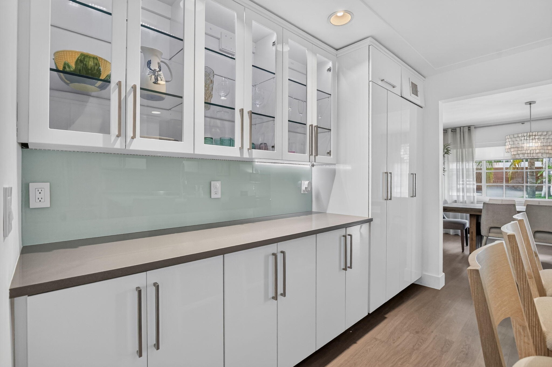Beautiful illuminated glass cabinets, the under cabinet lighting design provides a unique glow against the custom designed backsplash. Take a look at 
