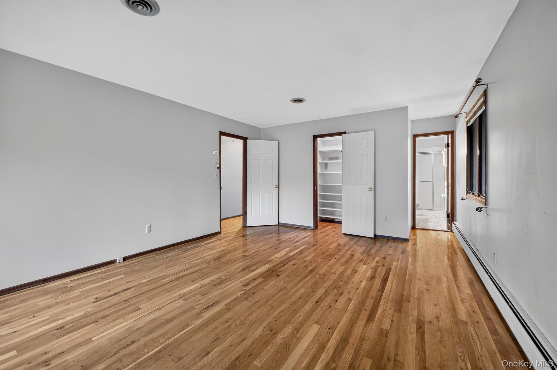 Hardwood flooring, light gray wall finishes, built-in closet , en-suite