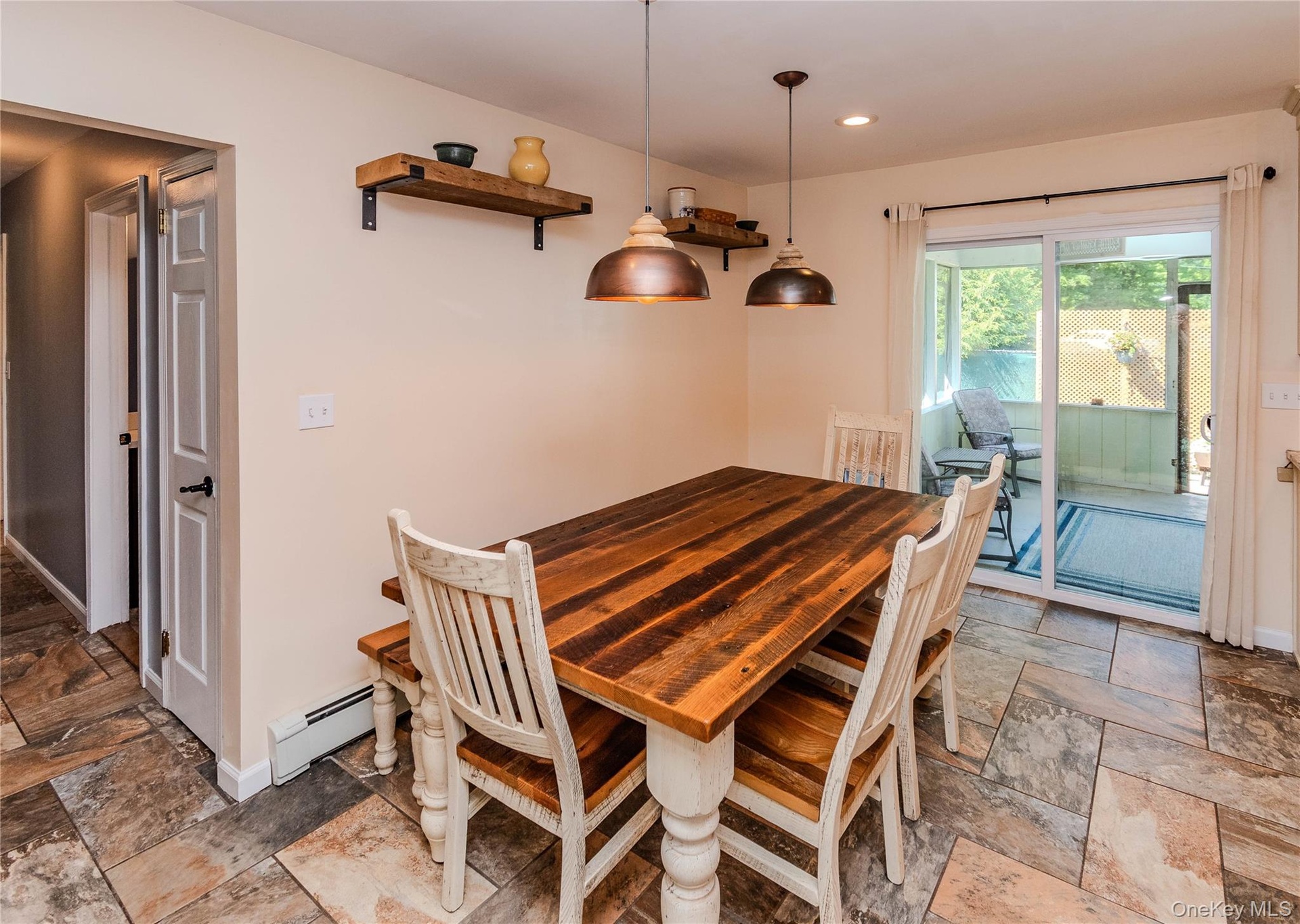 Tiled flooring throughout, featuring a dining area with two pendant lights and open shelving