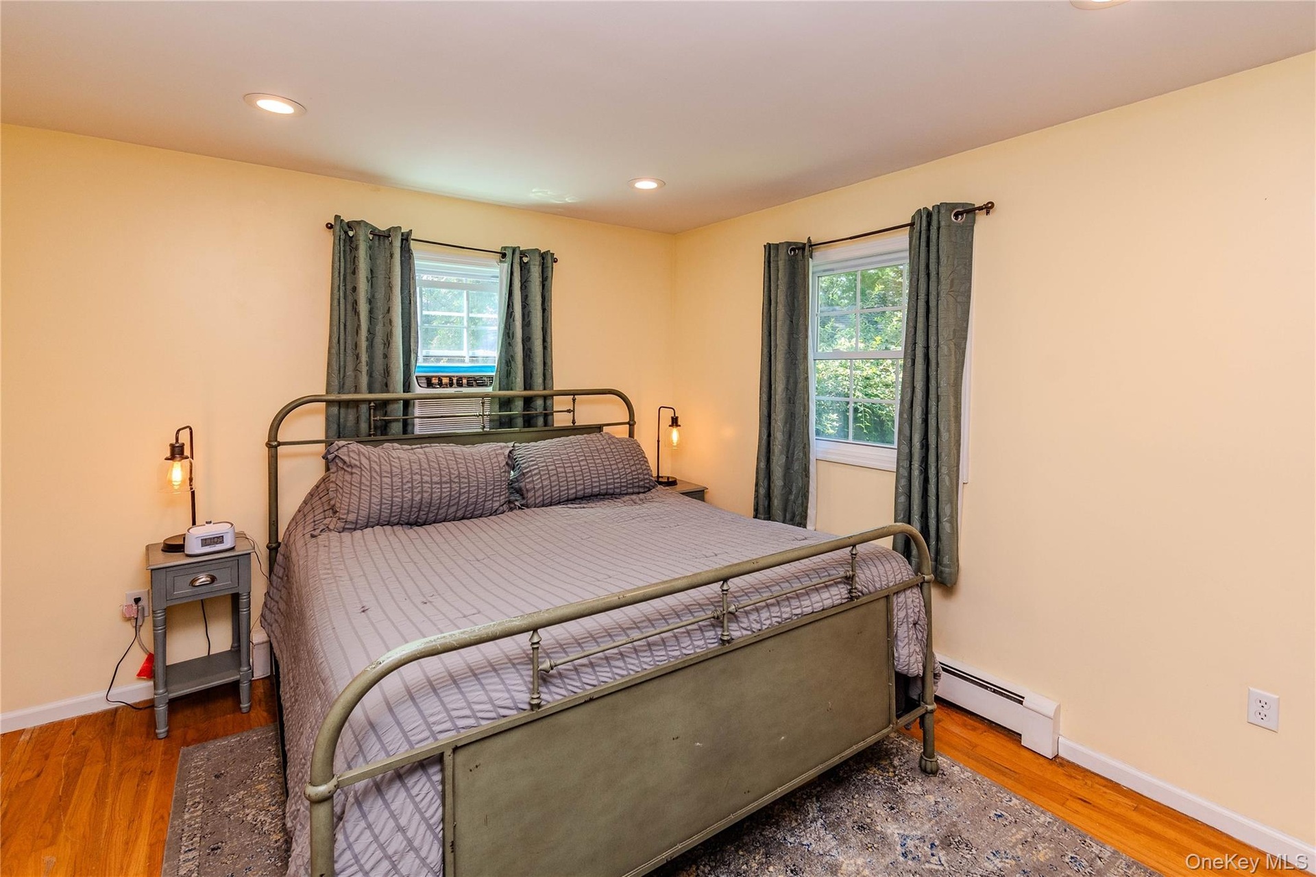 Hardwood flooring, recessed lighting, and two windows with natural light