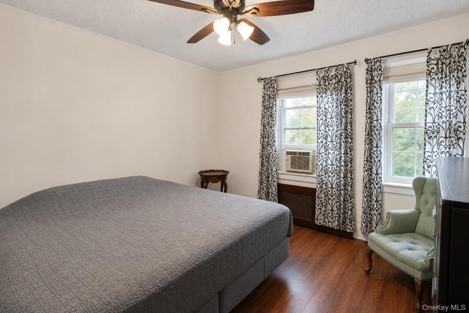 Wood-finish flooring, dual windows, and ceiling fan with integrated lighting