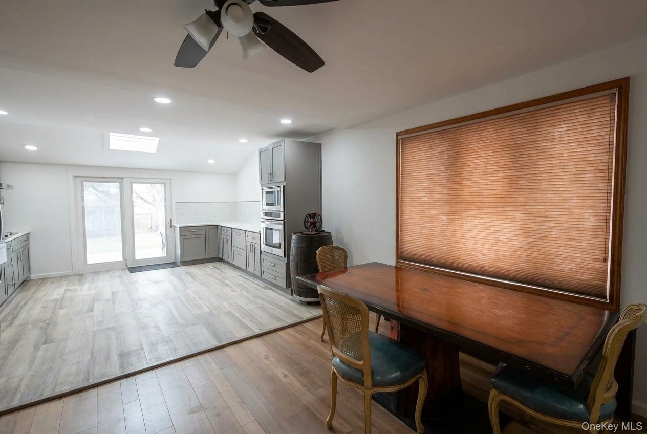 Recessed lighting, wood-finish flooring, skylight, ceiling fan, and sliding glass doors