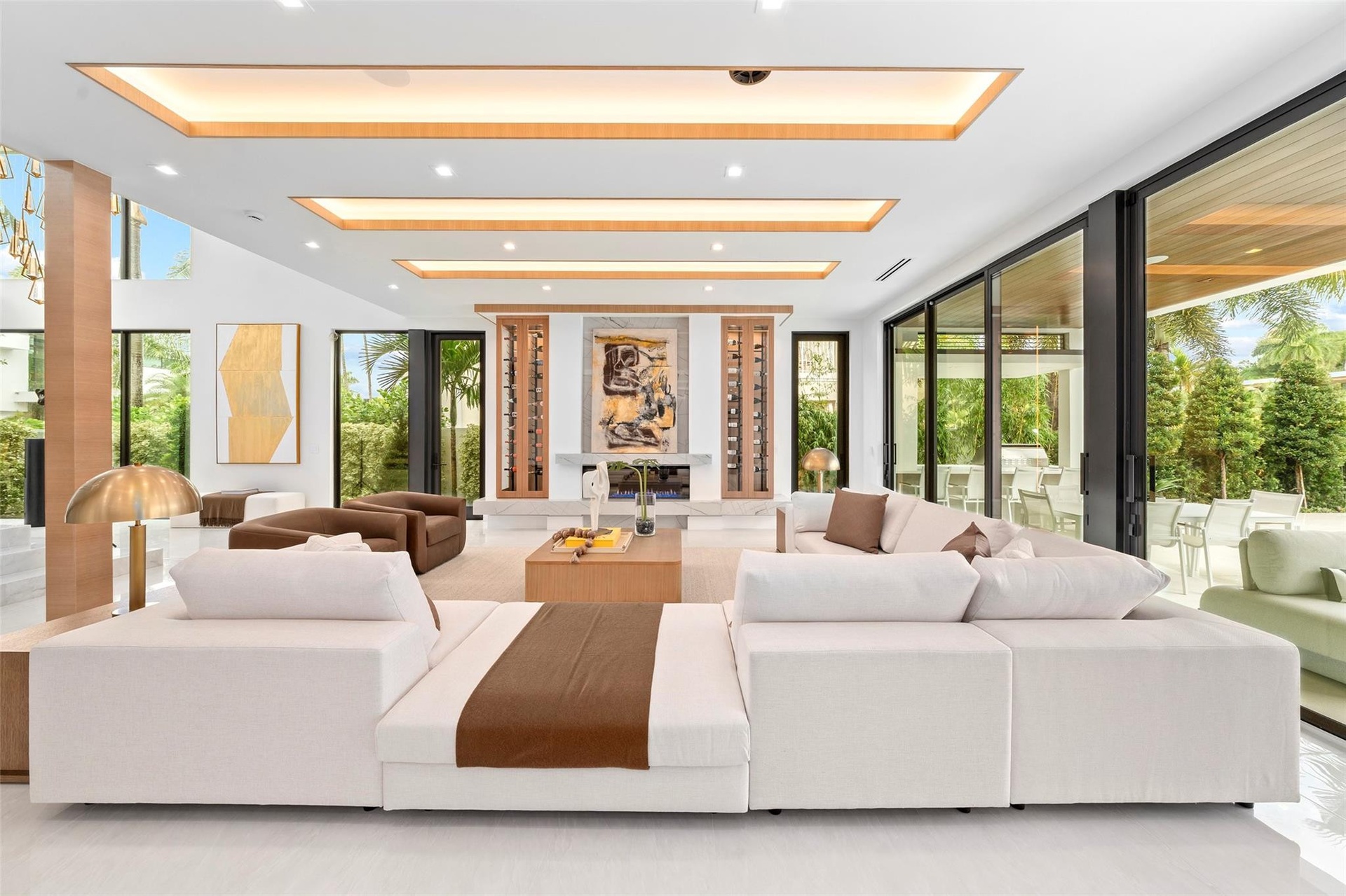The home features a beautifully designed formal living area with soaring ceilings, expansive windows, and stunning waterway views that capture the ess