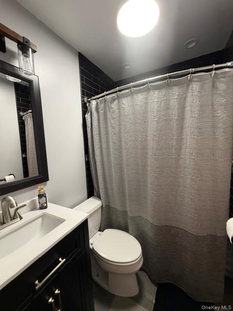 Bathroom featuring a dark subway tile shower surround, black vanity with gold-tone hardware, white countertop, and a brushed nickel faucet.Full Apt. #