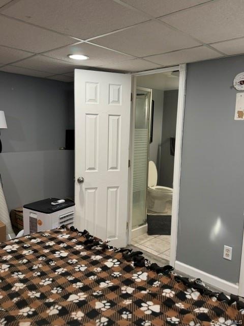 Recessed ceiling lighting, white paneled door, three-piece bathroom with glass-enclosed shower, tiled flooring in bathroom, light gray wall paint