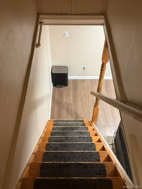 Wood staircase with dark carpet runners and a traditional wood handrail. Apt. #1 to full basement.
